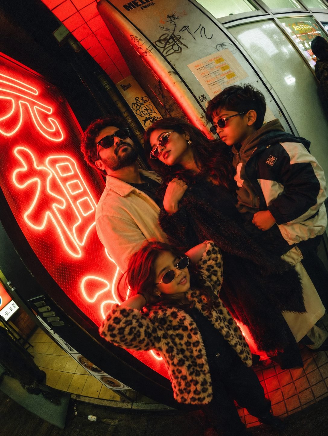 A family under red neon in Tokyo at night